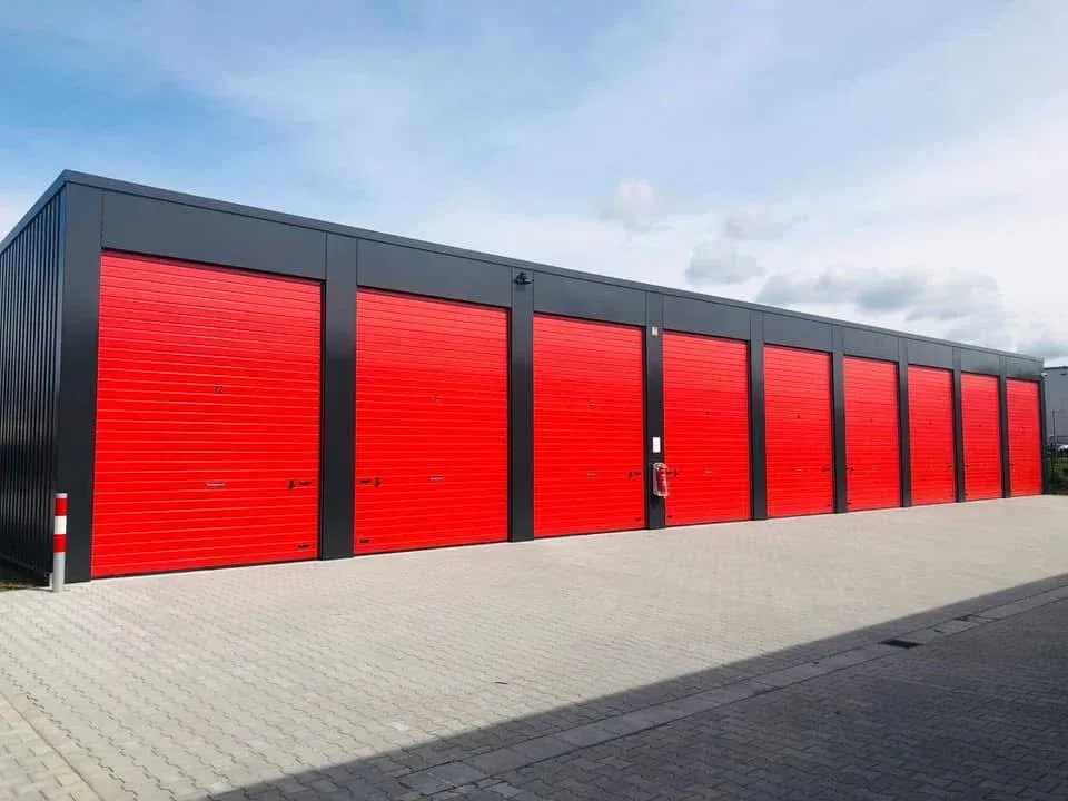 Reihe Garagen mit roten Sektionaltoren am Garagenpark Garagenlager24 bei Tageslicht