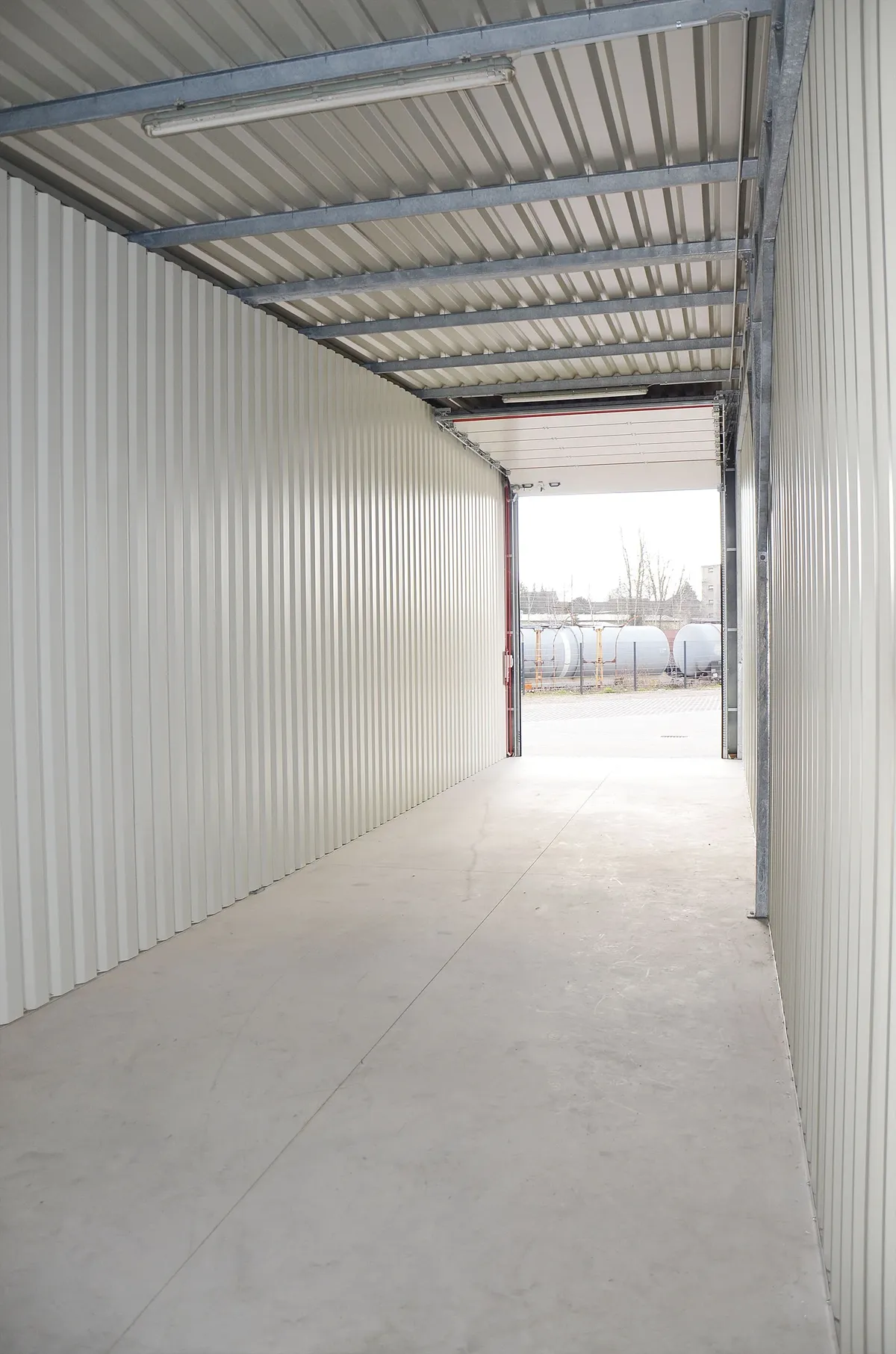 Blick durch eine offene Garage mit geöffnetem Tor auf den Garagenpark